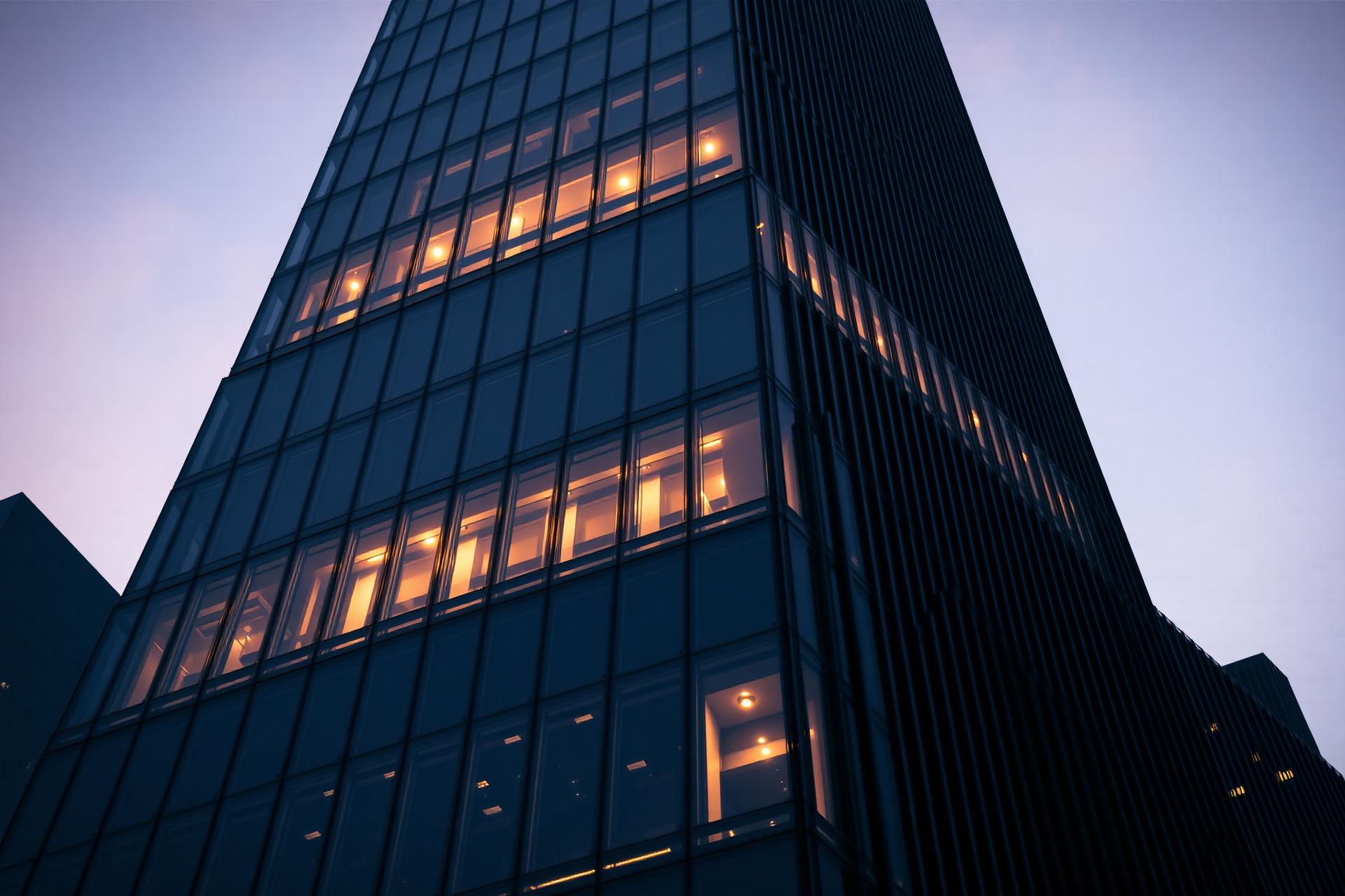 Modern obsidian tower at twilight with golden window light